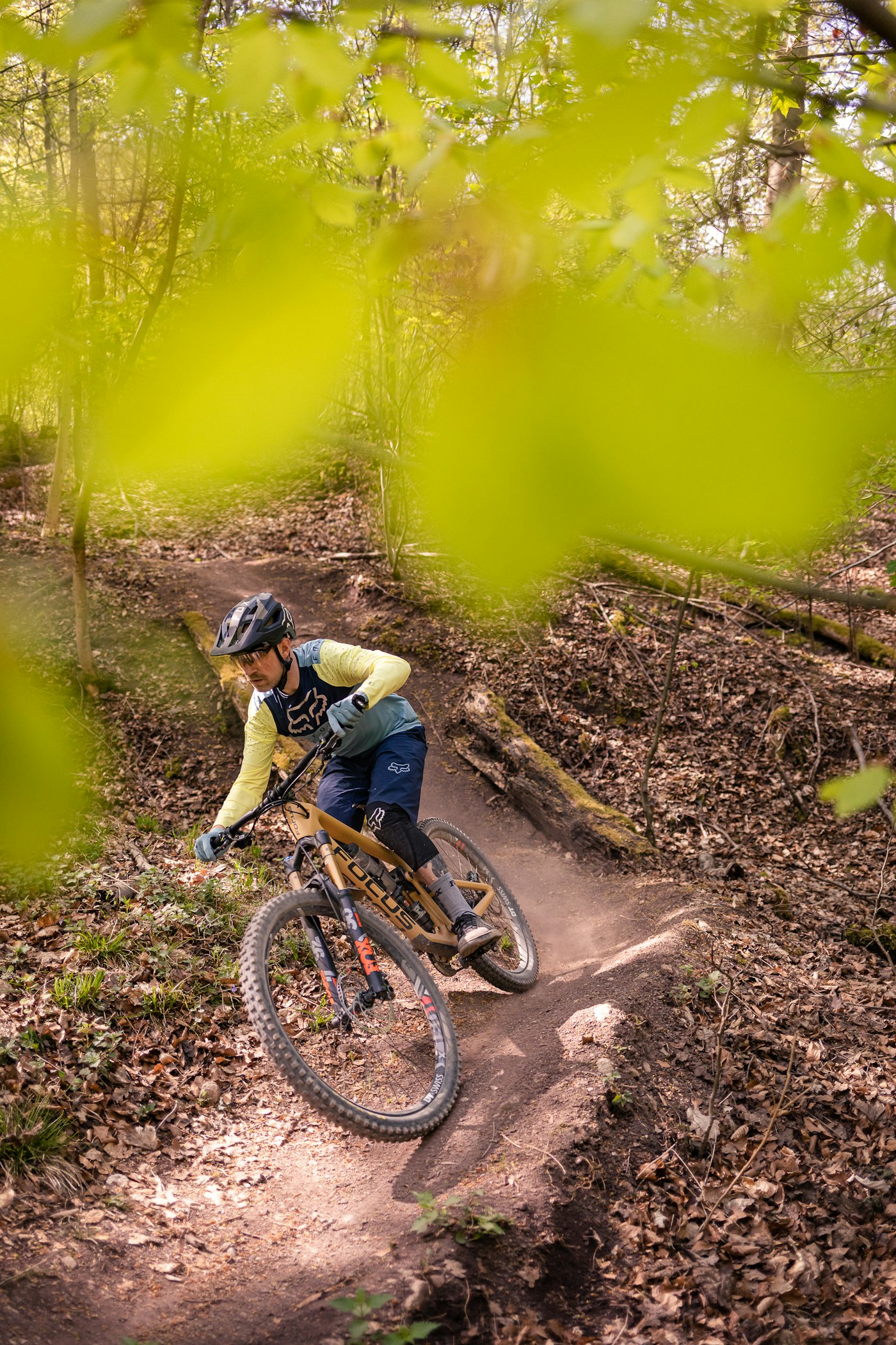 A mountain biker riding a dusty bend through the forest
